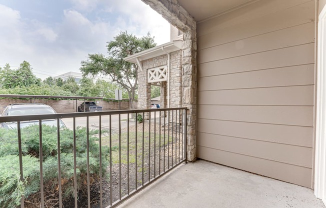 A balcony with a metal railing and a stone pillar.