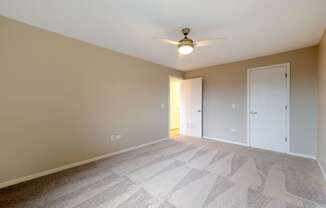 a spacious bedroom with carpet and a ceiling fan at Willow Hill Apartments, Justice, IL, 60458