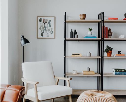 a living room with a book shelf and a chair