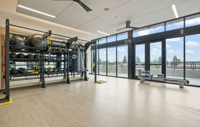 a large room with glass windows and a large metal structure with weights and other equipment in it