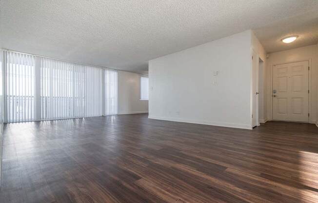 an empty living room with a large window at Park Avenue Apartments, Long Beach, CA