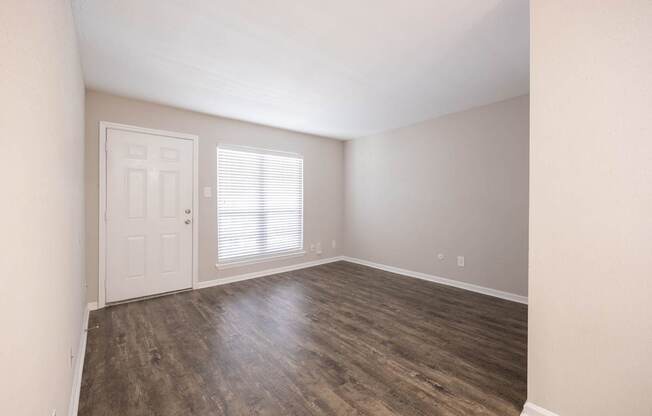 A room with a white door and a window with blinds.