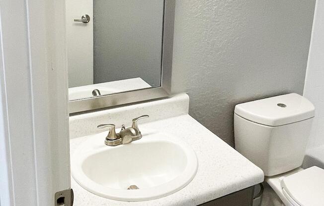 a sink sitting under a mirror