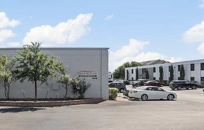 a parking lot with cars in front of a building at Brookside Apartments, Hewitt, TX, 76643