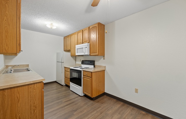 A kitchen with wooden cabinets and appliances.