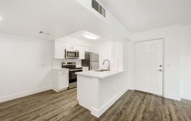 a white kitchen with a white counter top and