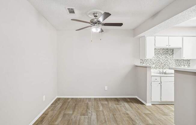 A6 dining room with a ceiling fan and vinyl wood flooring Windridge on the Parkway apartments in Dallas, TX.