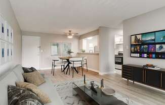 a living room with a couch and a coffee table in front of a dining area