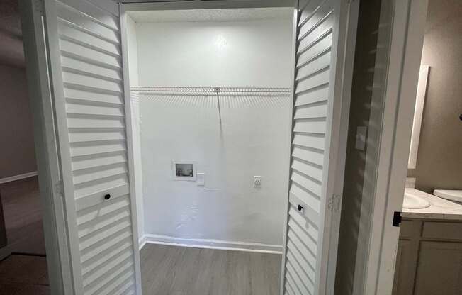A white closet with a light on.