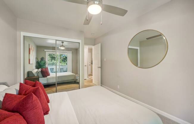 a bedroom with a white bed and a ceiling fan