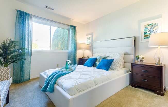 a bedroom with a white bed and blue pillows