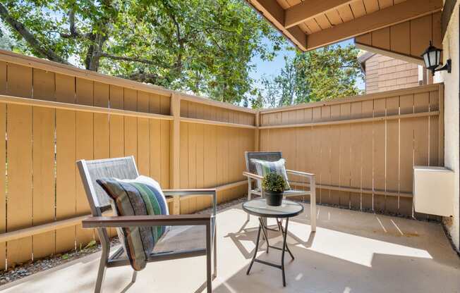 a patio with two chairs and a table on a porch