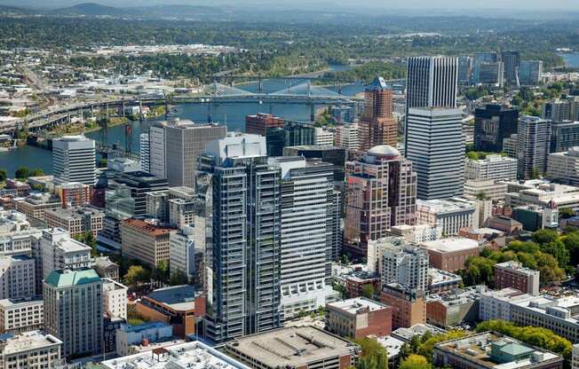 A cityscape with a river and a bridge in the background.