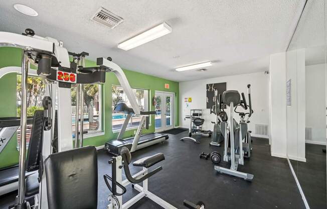 A gym with a treadmill, weights, and exercise equipment.