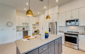 a large kitchen with stainless steel appliances and white cabinets