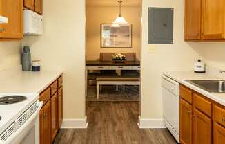 a kitchen with white appliances and wooden cabinets and a rug