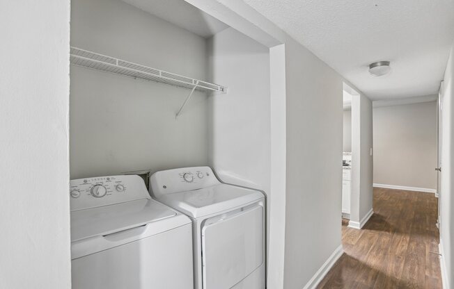 Two white front load washing machines in a laundry room.
