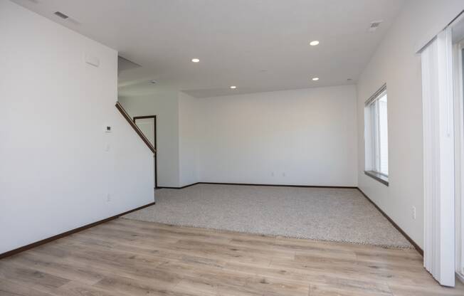 a living room with white walls and wood floors