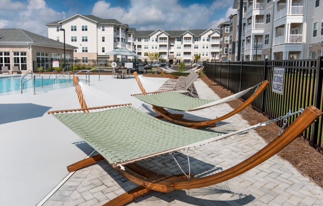 a row of hammocks on a patio next to a pool
