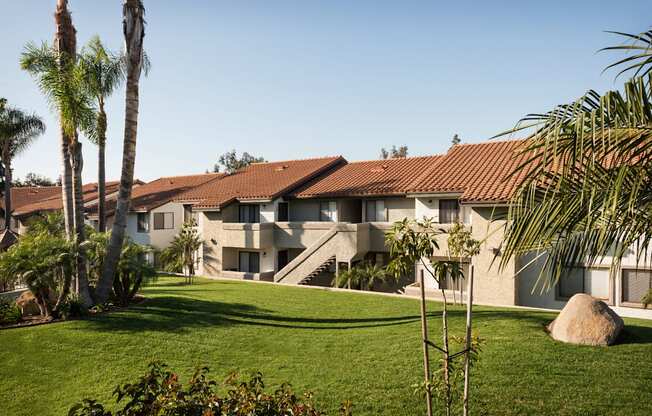 a row of apartment buildings with palm trees in the foreground
