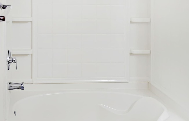 A white bathtub in a bathroom with a white door.