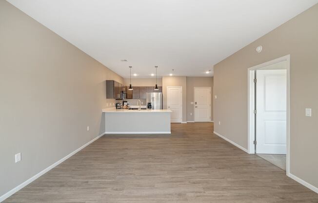 A spacious room with a kitchen island in the middle.