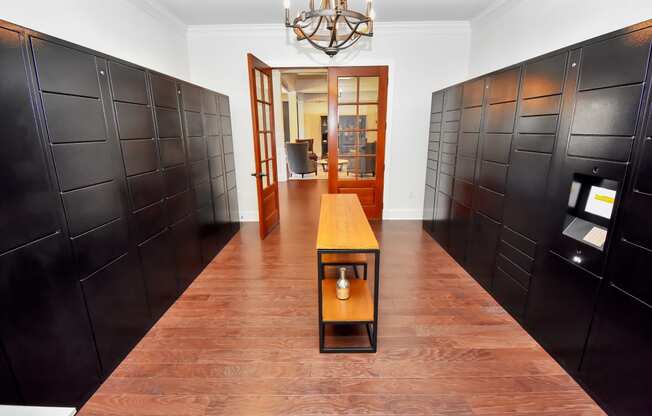 a long hallway with dark brown lockers and a small table