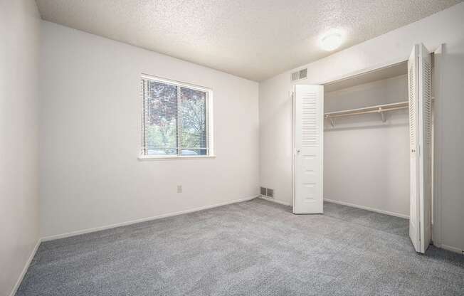 A bedroom with a window and a closet at Seville Apartments, Michigan
