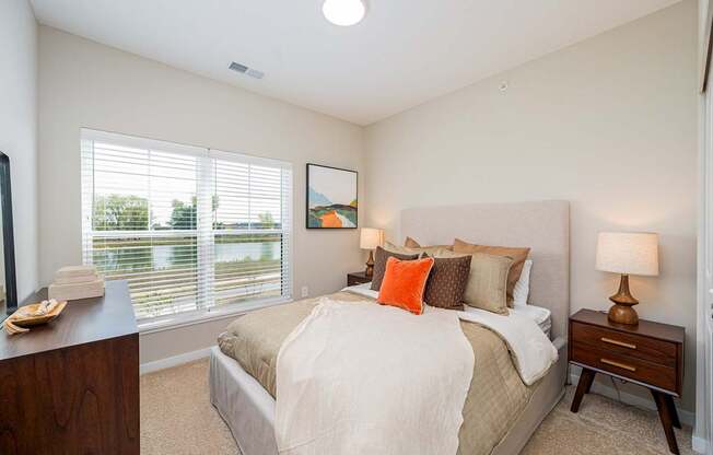 A bedroom with a large bed and a painting on the wall.