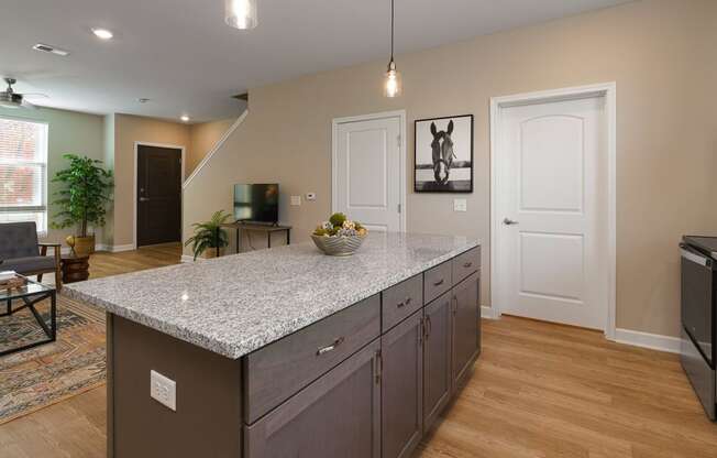 a kitchen with a granite counter top in the middle of a living room