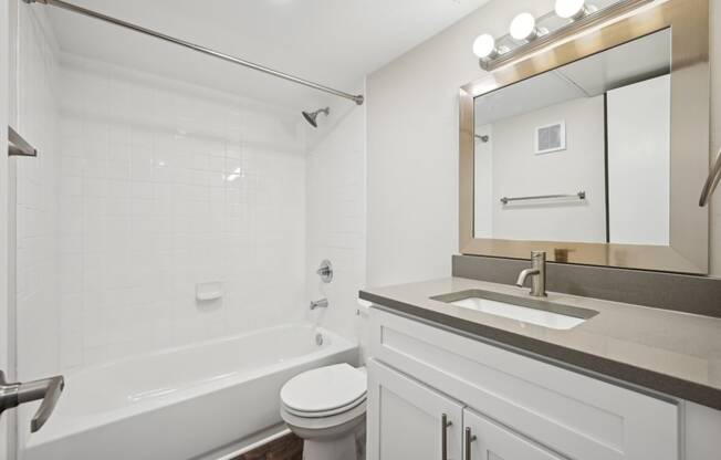 a bathroom with a sink and a toilet and a tub at Woodlands of Plano