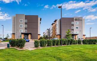 an exterior view of an apartment building with a parking lot at Parks Residential - Denver, Centennial, CO