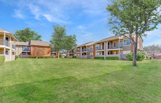 A grassy area in front of apartment buildings.