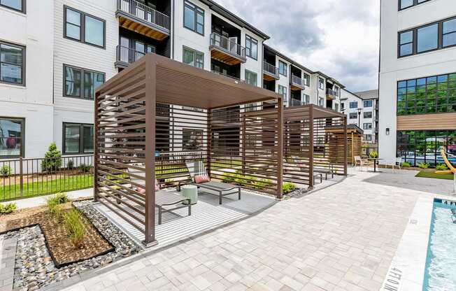 Sophisticated outdoor pool area with cabanas and lounge chairs at Novel Cary