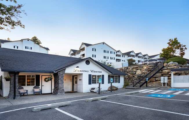 A white building with a black roof and a sign that reads "Flashing Center" sits in front of a parking lot.
