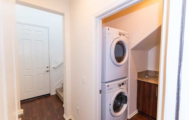 a washer and dryer in a laundry room with a white door at The Vines at Riverpark, LLC, California, 93036