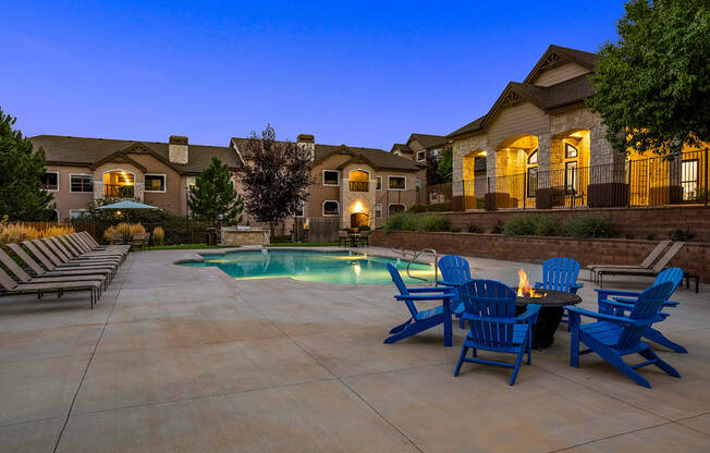 Poolside fire pit lounge at dusk - Grand Centennial Apartments