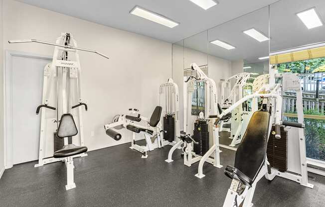 A gym with a variety of equipment including a leg press machine and a chest press machine.