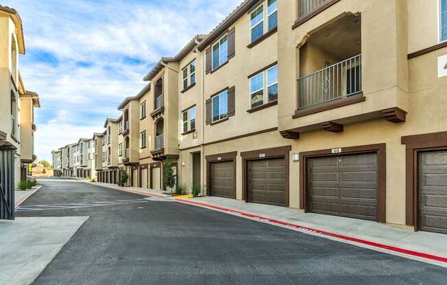 A row of apartment buildings with garages on the side.