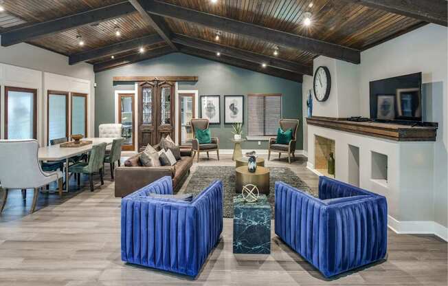 Clubhouse lounge with exposed beam ceiling, plush seating, and open gathering areas.