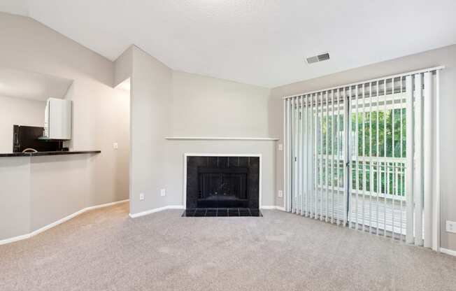 an empty living room with a fireplace and a window