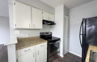 a kitchen with white cabinets and a black stove and refrigerator