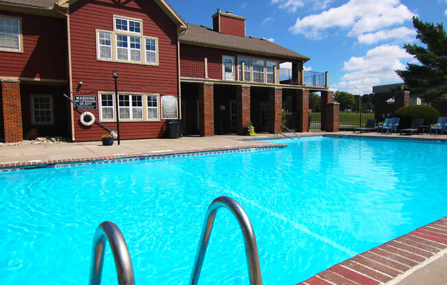 A swimming pool in front of a red brick building.