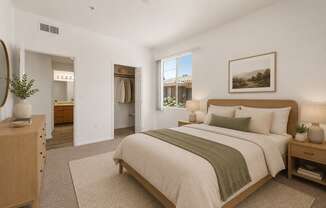 A bedroom with a large bed and a view of a house through the window.