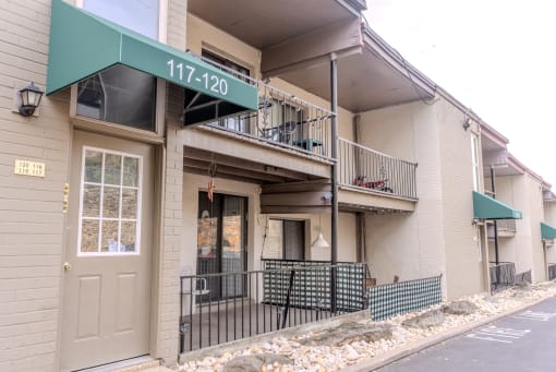 the front of a apartment building with a door and a balcony