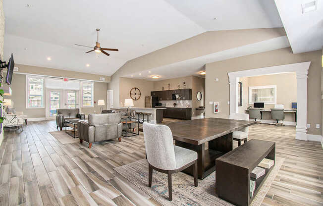 A spacious community room with a vinyl plank floor and a large table at Strathmore Apartment Homes, West Des Moines, IA