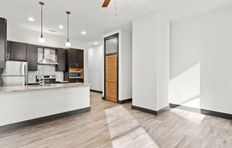 A modern kitchen with a white countertop and a wooden door.