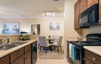 a kitchen with a stove and a sink and a dining room