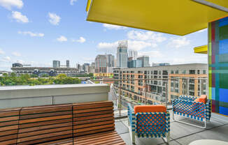 a rooftop terrace with chairs and a view of the city at Link Apartments® Mint Street, Charlotte, NC