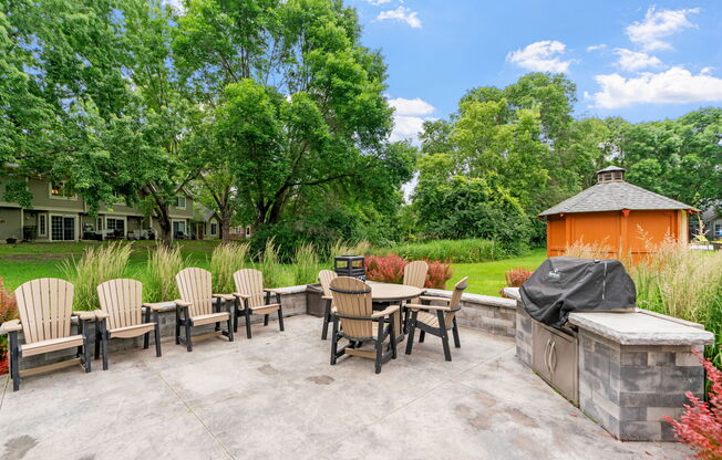 A patio with a table and chairs and a hot tub.